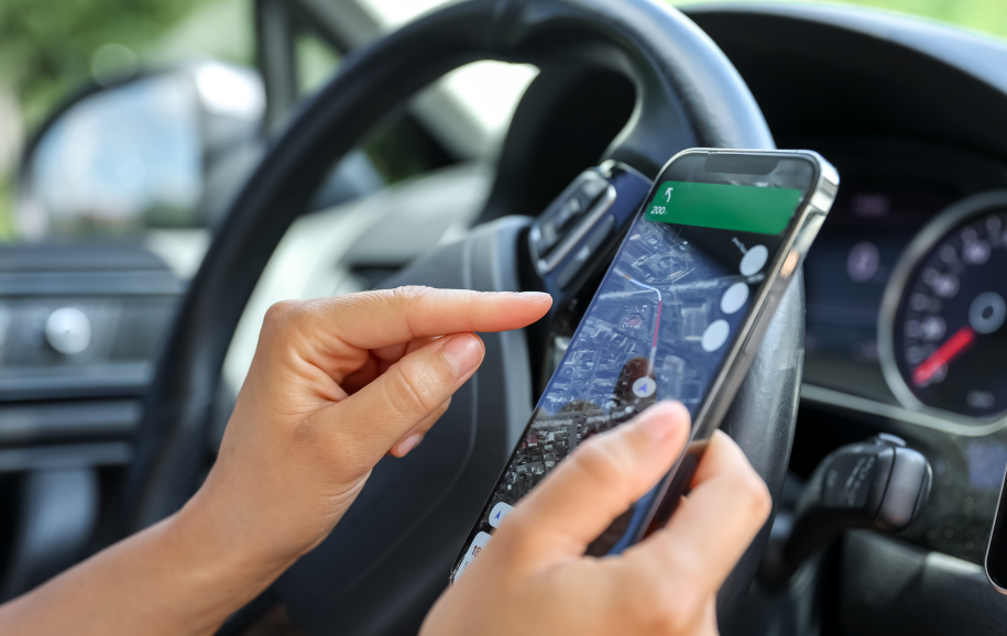 A woman driving a car use your smartphone to view a map showing your travel route and use the application to get to the destination.