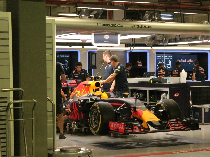 Red-Bull-F1-pit-crew-team-members-and-mechanics-in-pit-garage-with-F1-race-car