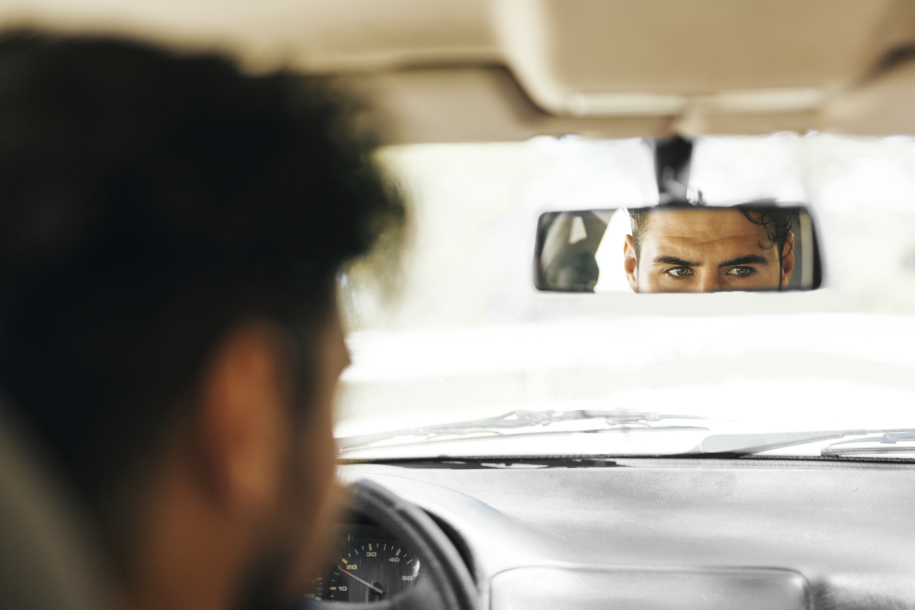 back-view-man-checking-car-mirror