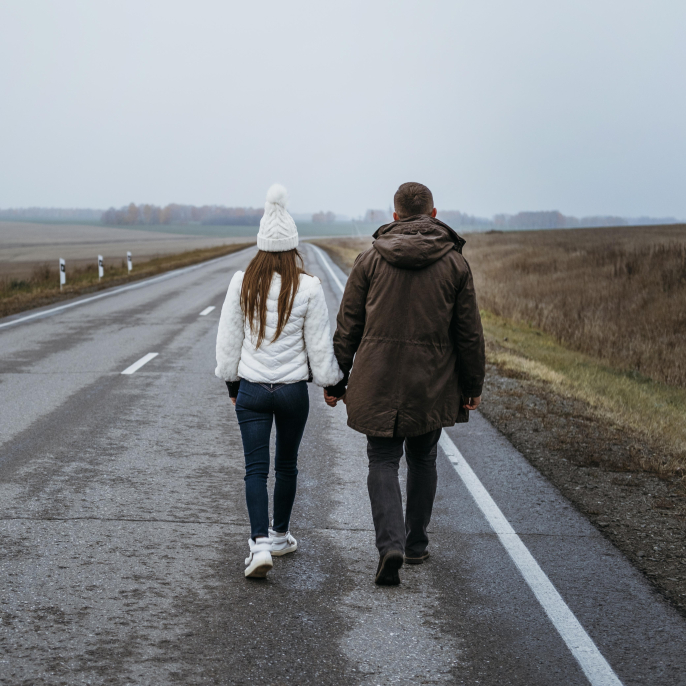 back-view-couple-holding-hands-road