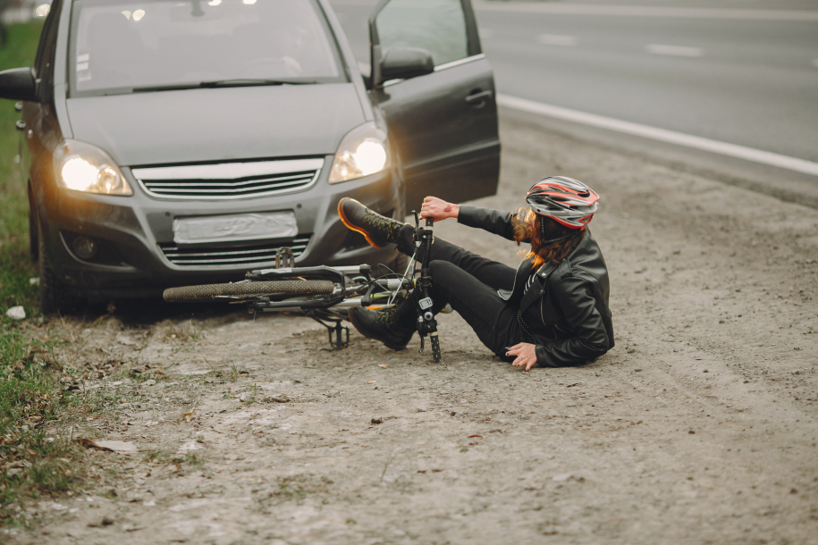 Road accident with cyclist woman driver and car