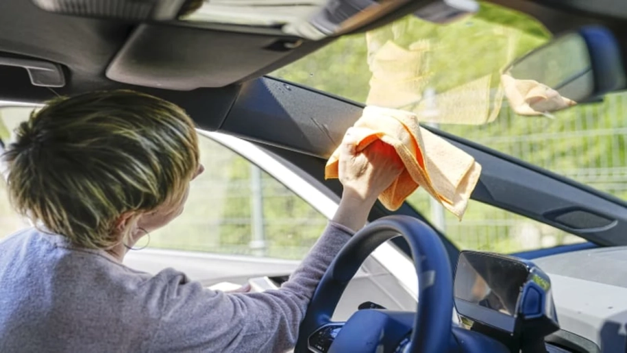 woman_cleaning_inside_of_car_windshield_at_a_sunny_service_area